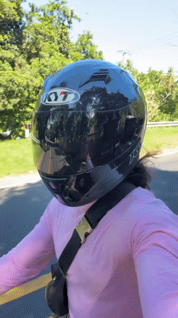 Motorcyclist rides through tropical road in Manggis, Indonesia