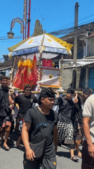 Traditional ceremonial procession carries ornate structure through Bedulu streets