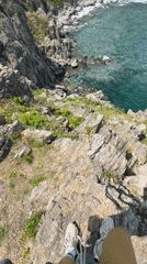 Visitors gather at scenic Russian coastal cliffs overlooking turquoise bay