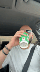 Driver drinks from Russian-labeled cup while driving