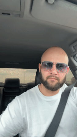Driver drinks from Russian-labeled cup while driving