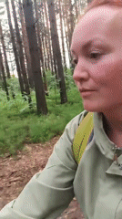 Woman cycles through pine forest near Chaikovsky, Russia