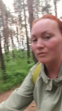 Woman cycles through pine forest near Chaikovsky, Russia