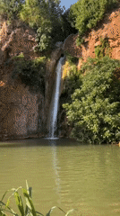 Sunlit waterfall into a green pool, Loulé, Portugal
