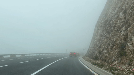 Driver navigates foggy mountain road in Montenegro