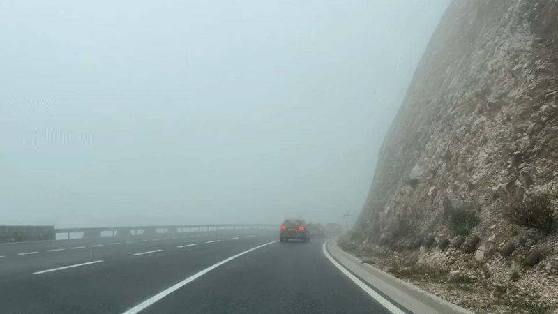 Driver navigates foggy mountain road in Montenegro