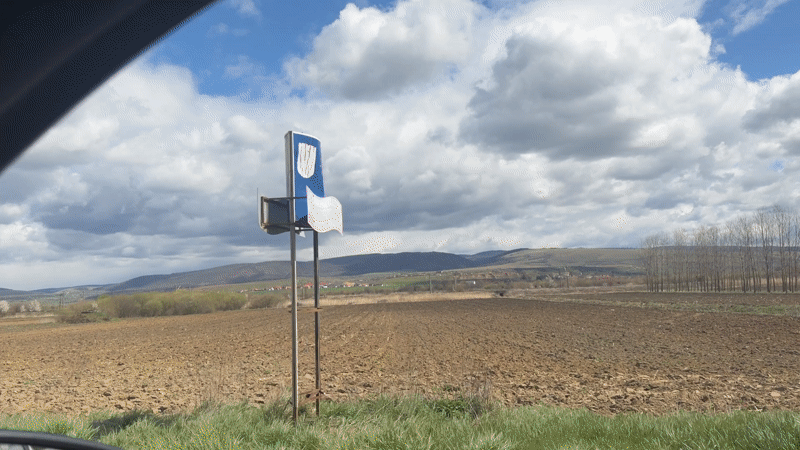 Horse-drawn wagon travels rural road in Măieruș, Romania