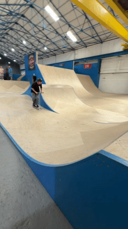 Scooter riders perform tricks at indoor skatepark in Ashfield