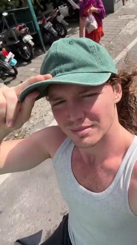 Young man films himself while riding vehicle in Kuta