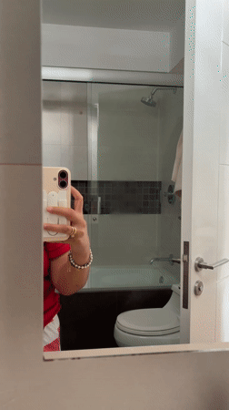 Woman takes bathroom selfie in San Isidro wearing Snoopy shirt