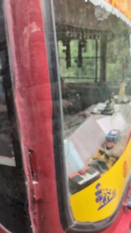 The video contains a shot of the interior of a red and yellow vehicle, with an altar including a small statue and toy vehicles on the dashboard. A later shot shows the interior of a bus, with passengers visible through the window, along with a sign in Hindi warning against drunk driving.