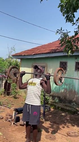 Man performs outdoor weightlifting workout in Akwanga, Nigeria