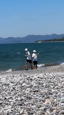 Beachgoers enjoy morning stroll along Fethiye rocky shoreline