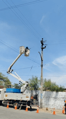Utility worker cleans power lines from bucket lift in Peru