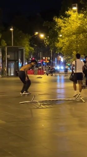 Nighttime skate tricks on a Barcelona plaza