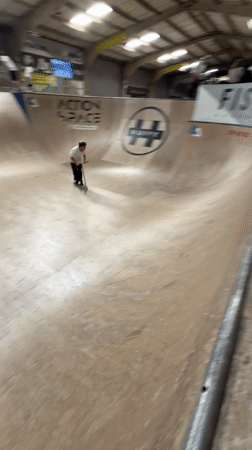 Scooter rider performs aerial tricks at Corby skate park