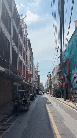 Morning traffic observed on narrow Bangkok street