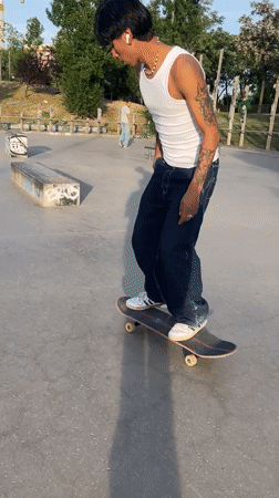 Tattooed skateboarder practices tricks at Madrid skate park evening