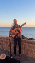 Street musician performs guitar set in Alghero, Italy