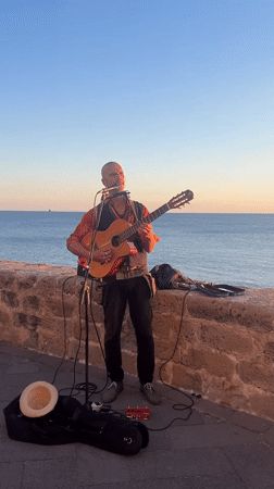 Street musician performs guitar set in Alghero, Italy