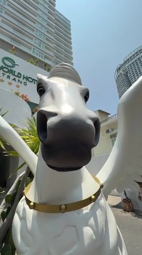 Tourist documents early morning Nha Trang cafe visit, hotel statue