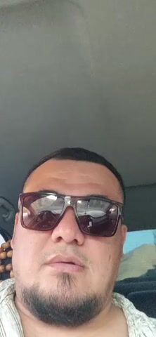The video begins with a close-up of a man wearing sunglasses and a beard, inside a car. The camera then shifts to an exterior view from inside the car, showing a highway with mountainous terrain in the background. Several vehicles, including cars and trucks, are visible on the highway. The dashboard of the car shows a speed of 59 and a temperature of 27 degrees. The scene appears to be a daylight drive.