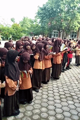 Students recite from books in an Indonesian schoolyard