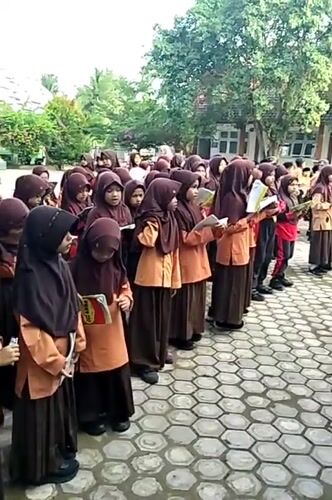 Students recite from books in an Indonesian schoolyard