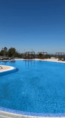 Empty outdoor pool with blue water documented by witness