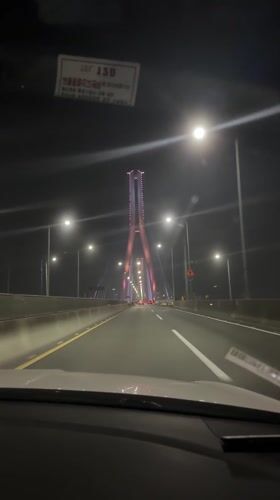 Night traffic on Busan bridge with tower structure visible