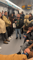 Accordion player performs for passengers on crowded subway car