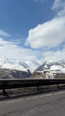 Snow-covered mountains observed along roadway in Gudauri, Georgia