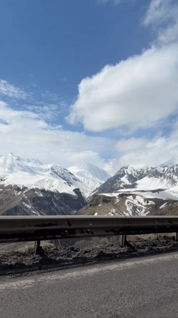 Snow-covered mountains observed along roadway in Gudauri, Georgia