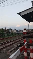 Passenger train crosses busy railway intersection in Semarang