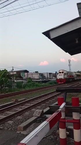 Passenger train crosses busy railway intersection in Semarang