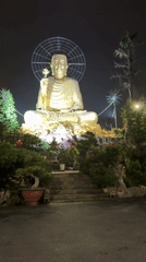 Golden Buddha statue illuminated at night in Đà Lạt