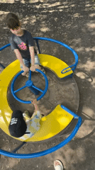 Children play on merry-go-round in Rusanovo park