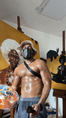Masked artist observed with paintings in Ado, Nigeria
