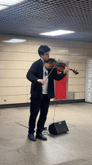Street musician performs violin in evening hours