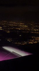 Nighttime aerial view captures illuminated Polish cityscape from airplane