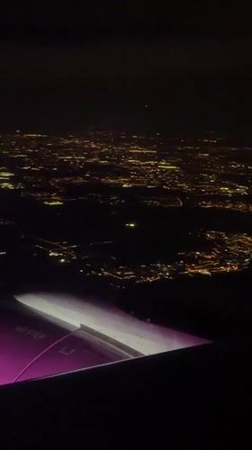 Nighttime aerial view captures illuminated Polish cityscape from airplane