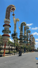 Traditional penjor bamboo decorations line Mengwi street in Bali