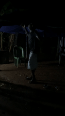 Man dances barefoot under canopy at night in Nigeria