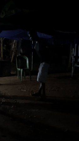 Man dances barefoot under canopy at night in Nigeria