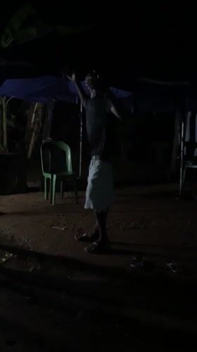 Man dances barefoot under canopy at night in Nigeria