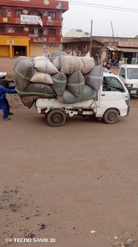 Men Push Loaded Truck on Dirt Road in Nigeria