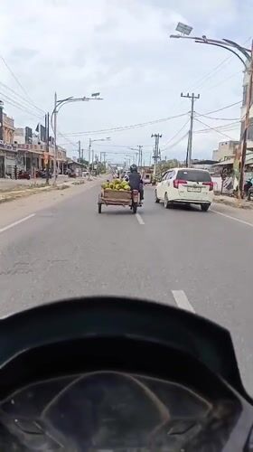 Motorcycle rider records road travel in Lhokseumawe, Indonesia