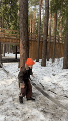 Child explores snowy forest park with birdhouses in Votkinsk