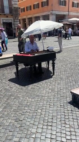 Street musician performs on piano in Rome square