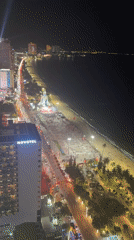 Nighttime coastal city scene captured from high vantage point